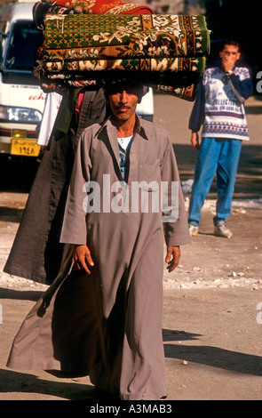 Tapis homme porte sur sa tête dans la rue en Egypte Banque D'Images