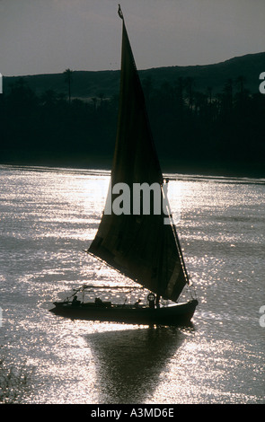 Felouque glisse le long fleuve du Nil en Egypte la lumière d'argent Banque D'Images