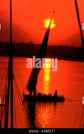 Felouque le long fleuve du Nil en Egypte coucher du soleil rouge Banque D'Images