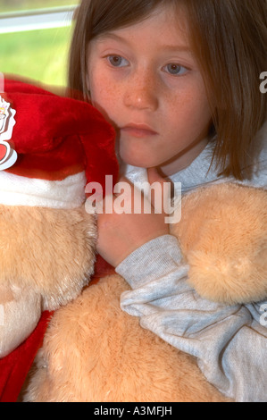 Vie en famille, le matin de Noël cadeaux jour 1 une jeune fille 6 7 6 7 ans ours en peluche santa hat Banque D'Images