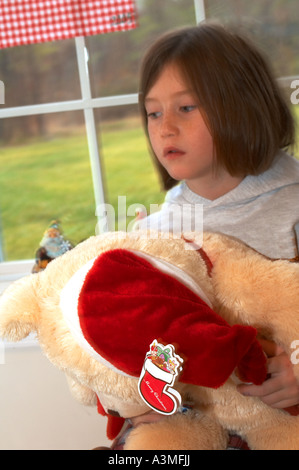 Vie en famille, le matin de Noël cadeaux jour 1 une jeune fille 6 7 6 7 ans ours en peluche santa hat Banque D'Images