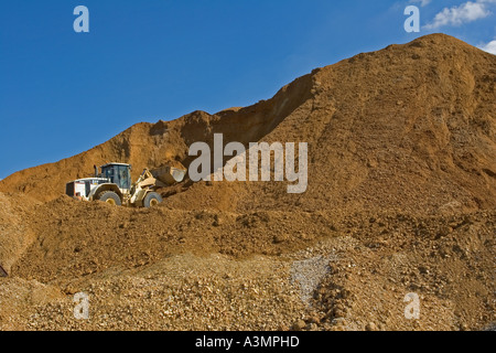 Avec chargeur avant de grès et de gravier à l'état brut des stocks de matières premières avant transformation à quarry Banque D'Images