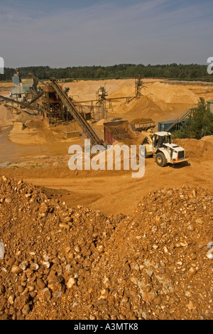 Trémie de chargement avec pelle de gravier provenant de stocks de matières premières avant transformation à quarry Banque D'Images