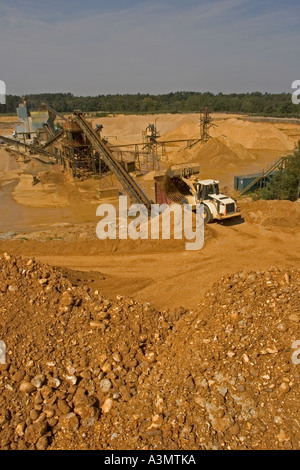 Trémie de chargement avec pelle de gravier provenant de stocks de matières premières avant transformation à quarry Banque D'Images