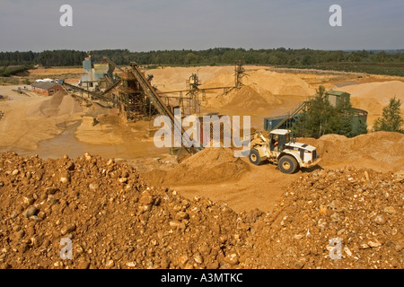 Trémie de chargement avec pelle de gravier provenant de stocks de matières premières avant transformation à quarry Banque D'Images