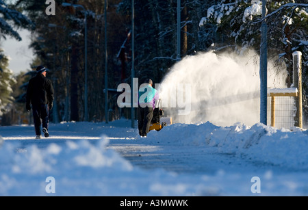 Un homme âgé à l'aide d'un petit la souffleuse pour retirer la neige , Finlande Banque D'Images