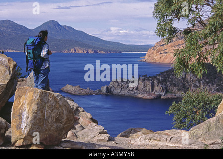 Un bushwalker s'arrête pour admirer la vue panoramique à partir de la Péninsule de Freycinet sur la côte est de Tasmanie Banque D'Images