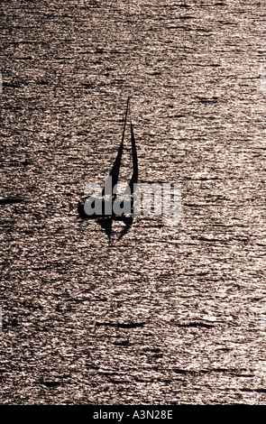 Les location de voile sur le coucher du soleil en mer texturé Banque D'Images