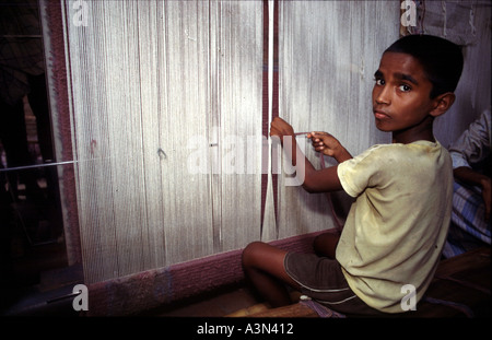 Un enfant travaille dans les fabriques de tapis d'Uttar Pradesh en Inde Les enfants sont victimes de la servitude pour dettes de Bihar et le Népal leurs petits doigts sont habiles à manipuler les threads les tapis pour vendre des milliers de dollars à New York et à Paris, les enfants qui les fabriquent sont essentiellement des esclaves Banque D'Images