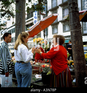 Jeune couple d'ACHETER DES FLEURS PAR UN FLEURISTE DE LA RUE DE L'île de Madère FUNCHAL PORTUGAL Banque D'Images