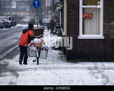 TNT mailwoman dame travaillant dans des conditions de mauvais temps d'hiver faute Breda Pays-Bas Banque D'Images