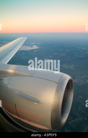 Moteur à réaction et l'aile en vol au coucher du soleil Banque D'Images