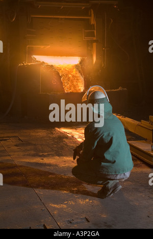 Travailleur de l'usine sidérurgique de laitier pour regarder au large de métal en fusion dans un four électrique à arc, usine de recyclage de l'acier, USA Banque D'Images