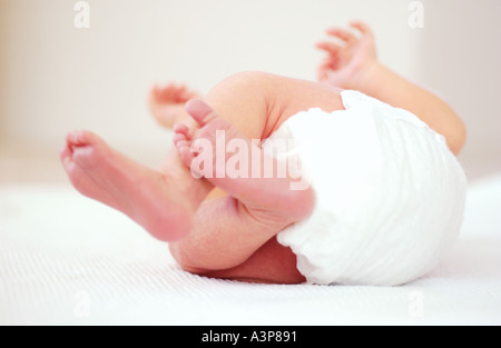 Bébé nouveau-né allongé sur le dos en essayant de rouler sur Banque D'Images