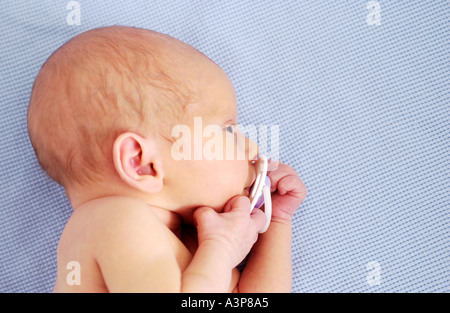 Bébé nouveau-né agrippé sucette Banque D'Images