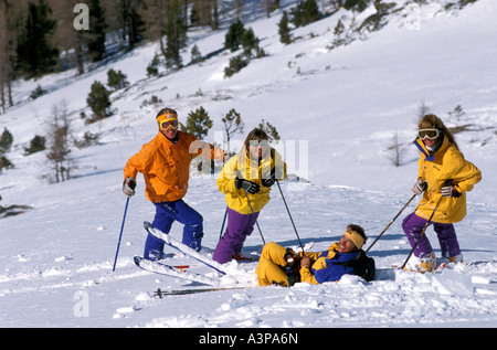 Groupe d'hommes et de femmes mi années '20 sur les pentes de rire et s'amuser hors piste à la poudreuse fraîche Banque D'Images