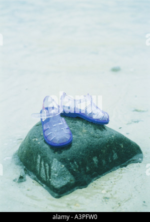 Jelly shoes on rock at beach Banque D'Images