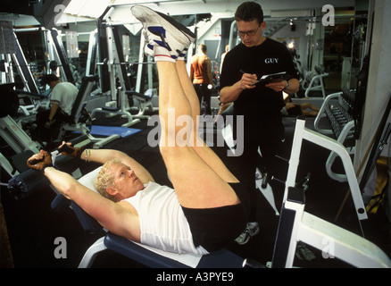 Homme qui garde la forme dans un gymnase Keep Fit avec personnel Trainer Londres 2000 UK HOMER SYKES Banque D'Images
