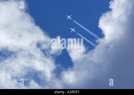 Deux avions de passagers blanc avec des traînées de vapeur dans le ciel bleu Banque D'Images