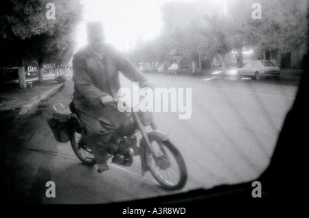 Scène de rue surréaliste d'un homme sur une Vespa scooter en ville nouvelle Fès au Maroc au Maghreb en Afrique du Nord Sahara. Voyage Transport infrarouge Banque D'Images
