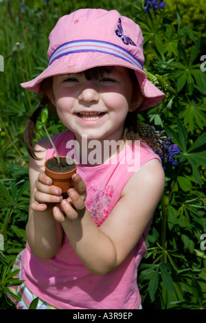 Une fille de cinq ans avec un semis de tournesol Banque D'Images