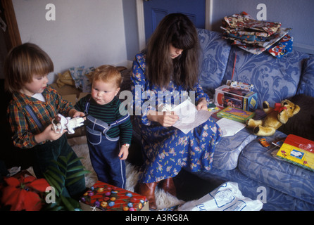 Famille UK 1970 Mère et deux jeunes garçons à Noël présente l'ouverture et faire une liste Londres 1970 La vie de famille de la classe moyenne HOMER SYKES Banque D'Images