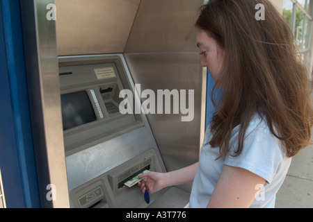 Adolescent utilise un distributeur automatique pour retirer de l'argent à partir de la Banque mondiale Banque D'Images