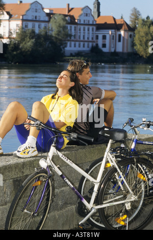 Biker reposant sur un mur à un lac, Autriche Banque D'Images