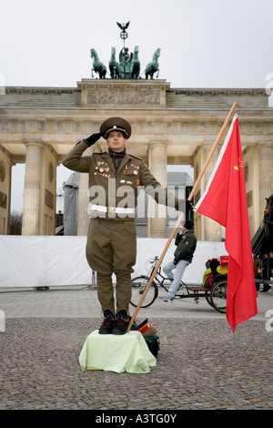 Un homme habillé comme un soldat de l'armée soviétique pose devant la Brandenburger Tor, Berlin Banque D'Images