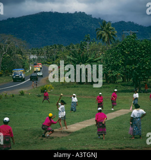 Mesdames dans village local traditionnel semblable à kirikiti jouer cricket sur les espaces verts sur l'île d'Upolu Samoa occidentales Banque D'Images