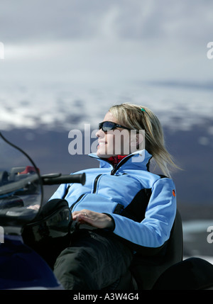 Femme sur les motoneiges, le glacier de Langjökull, Islande Banque D'Images