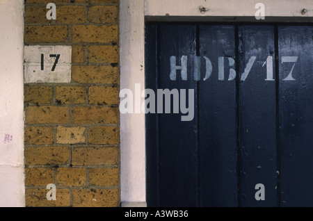 Numéro 17 17 marqué au pochoir sur mur de brique et un panneau de bois à une gare ferroviaire dans le nord de Londres avec graffiti written Banque D'Images