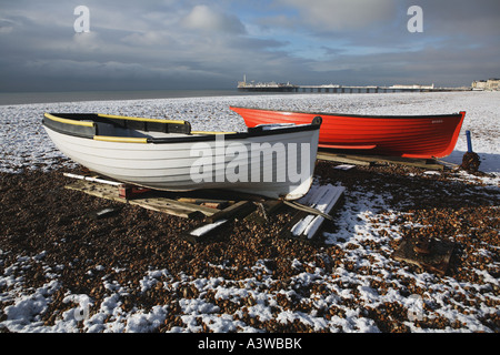 Deux petits bateaux de pêche sur la neige a couvert la plage de Brighton, East Sussex, Angleterre Banque D'Images