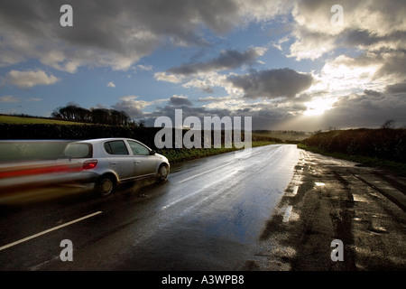 Vitesse, conduite rapide de la voiture sur route mouillée vers les nuages de tempête, île de Wight, Angleterre Royaume-Uni Banque D'Images