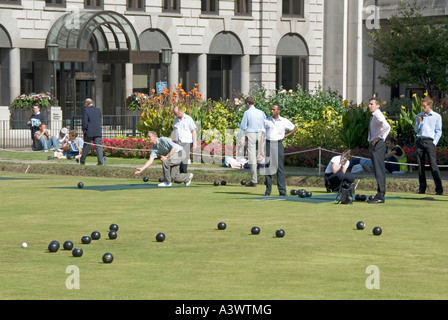 Jeu de boules sur un terrain de bowling à l'heure du déjeuner sous la surveillance des employés de bureau lors d'un chaud jour d'été, Finsbury Square Londres Angleterre Royaume-Uni Banque D'Images