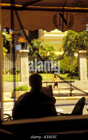 L'homme assis à la Café Napoléon à Ajaccio Corse France journal de lecture Banque D'Images