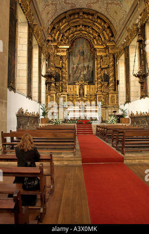 Femme en prière à l'intérieur de l'église catholique.S. Monastère de Bento à Santo Tirso, le Portugal. Ordre des Bénédictins. De style baroque (église). Banque D'Images