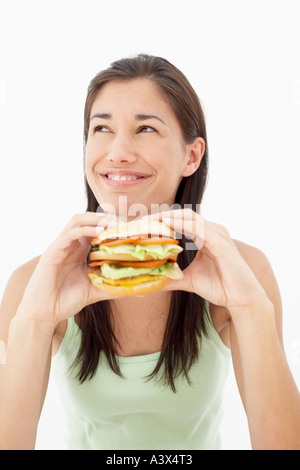 Une jeune femme mangeant un hamburger Banque D'Images