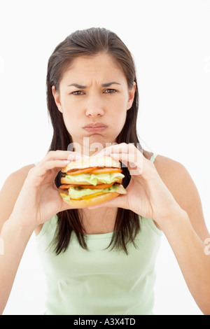 Une jeune femme mangeant un hamburger Banque D'Images