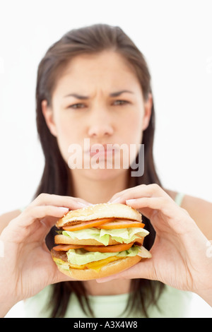 Une jeune femme mangeant un hamburger Banque D'Images