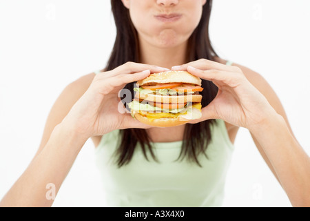 Une jeune femme tenant un hamburger Banque D'Images