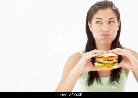 Une jeune femme mangeant un hamburger Banque D'Images