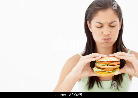 Une jeune femme mangeant un hamburger Banque D'Images