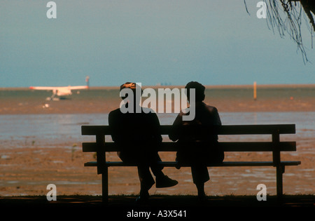 Couple sur banc de l'esplanade Cairns Harbour Trinity Inlet à marée basse Queensland Australie Banque D'Images