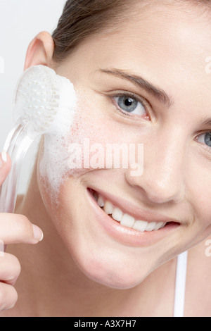 Close up of a young woman face massage avec brosse Banque D'Images