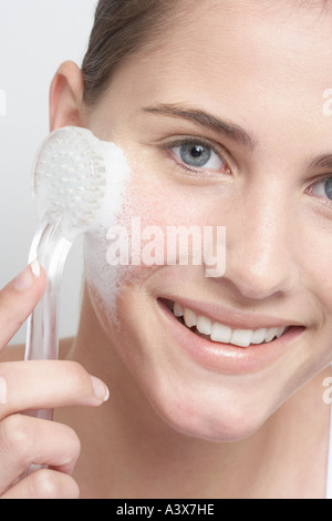 Close up of a young woman face massage avec brosse Banque D'Images