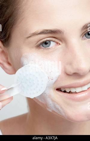 Close up of a young woman face massage avec brosse Banque D'Images