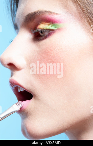 Close up of a woman applying lipstick Banque D'Images