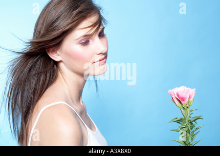 Portrait of a young woman looking at a flower Banque D'Images