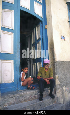 L'homme et jeune garçon assis à leur porte avant dans la vieille Havane Cuba Banque D'Images